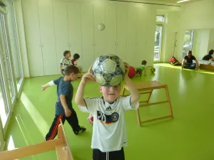 Ein Kind spielt im Bewegungsraum mit einem Fußball