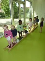 Kinder balancieren auf einer niedrigen Holzbank